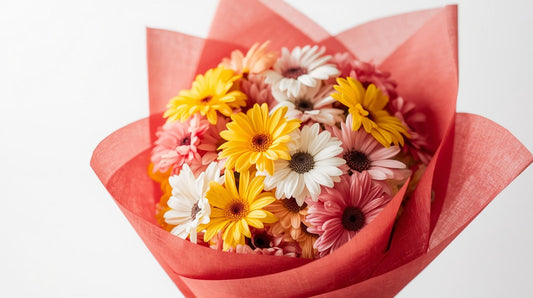 Bouquet of flowers wrapped in red paper on a white background