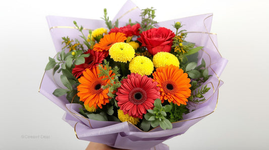 Bouquet of colorful flowers in a purple wrap on a white background