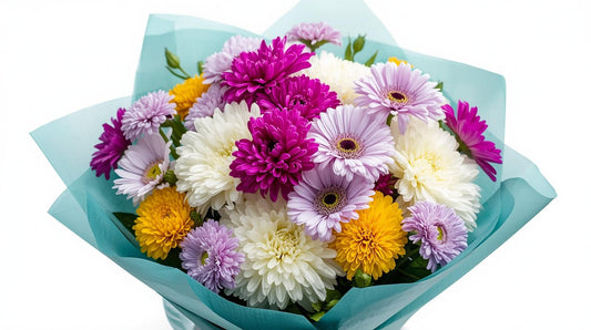 Bouquet of colorful flowers wrapped in blue paper on a white background
