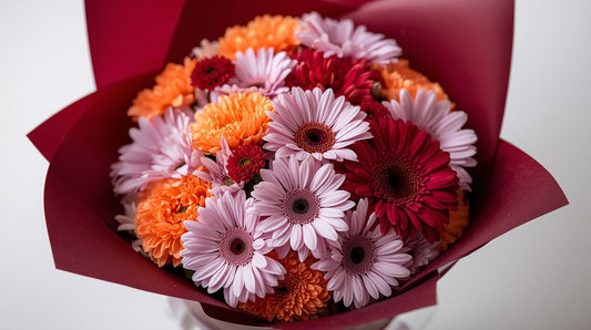 Bouquet of colorful flowers in a red paper wrap on a white background